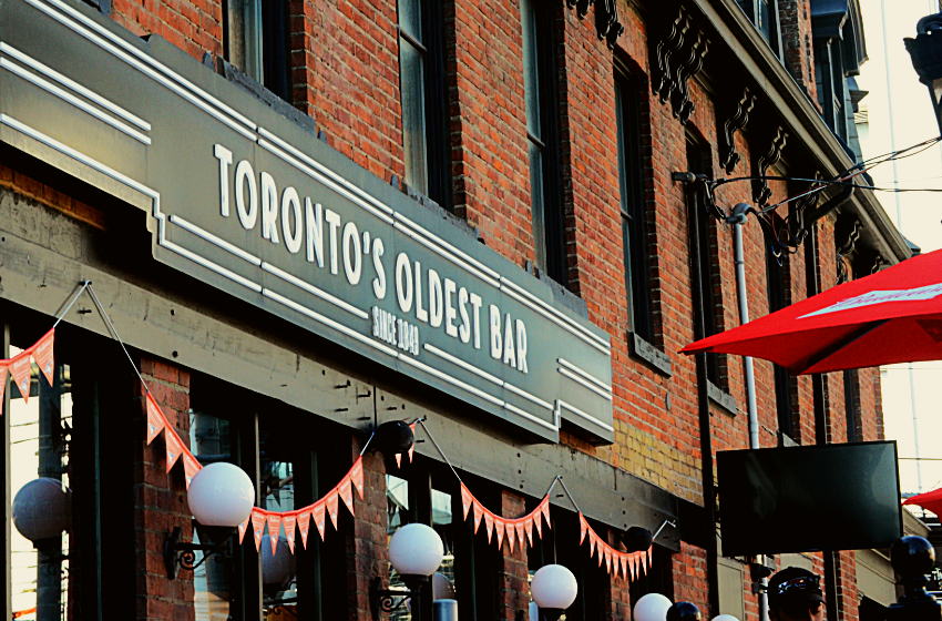 The storefront of a bar in Toronto with a sign reading 'Toronto's Oldest Bar'.
