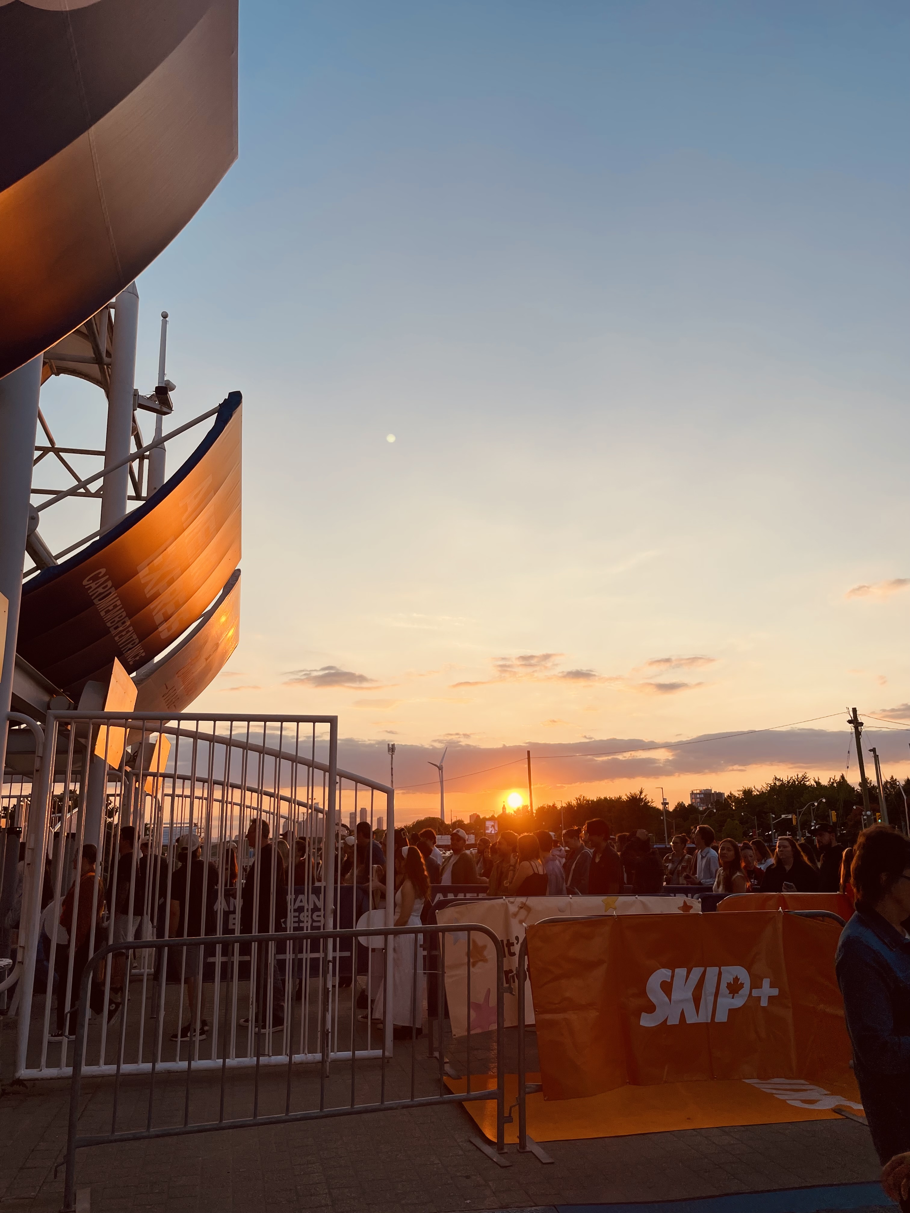 Sun setting behind a crowd of people outside of Budweiser stadium.