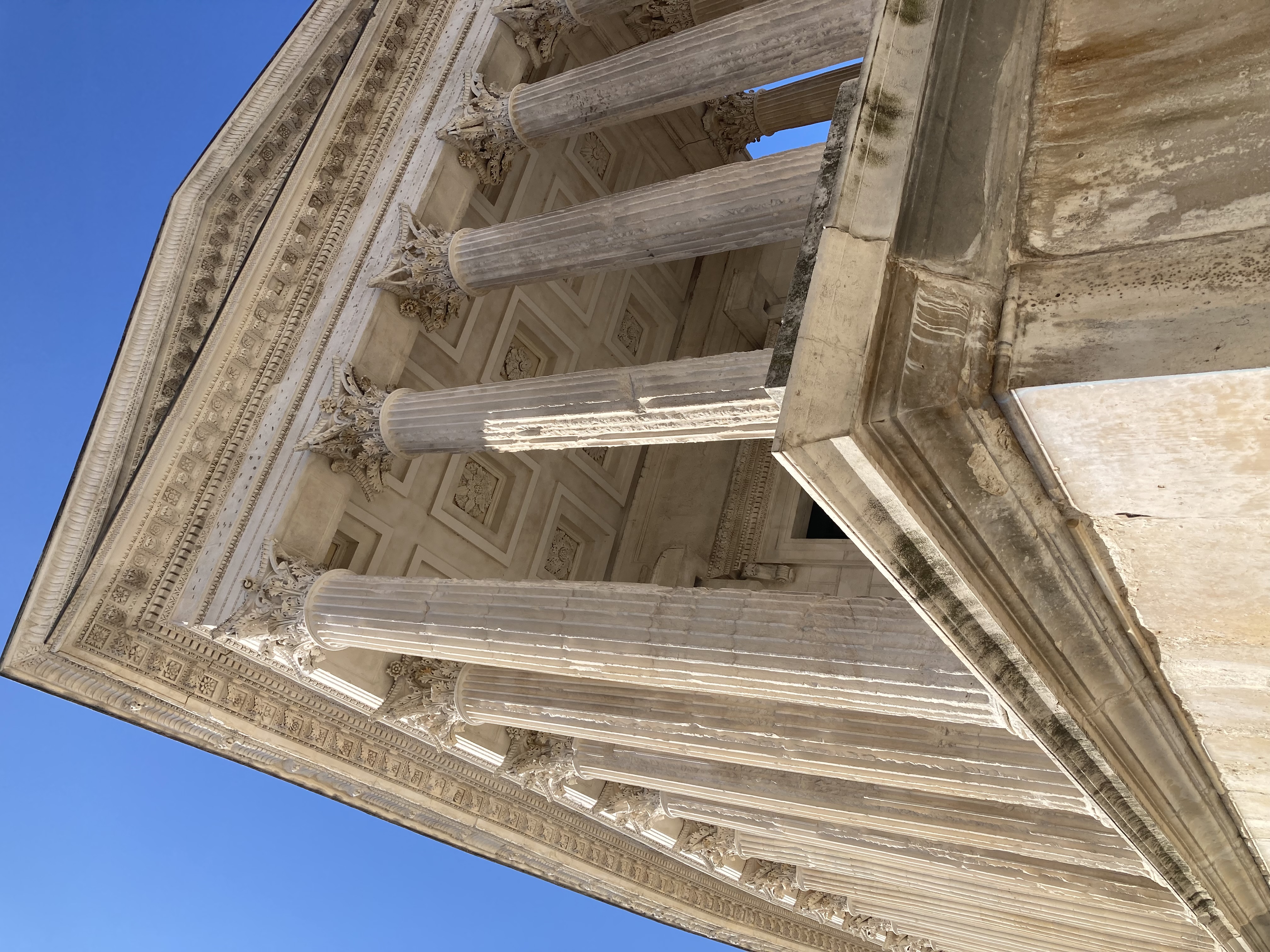 The front pillars of a stone Roman collosseum in France.