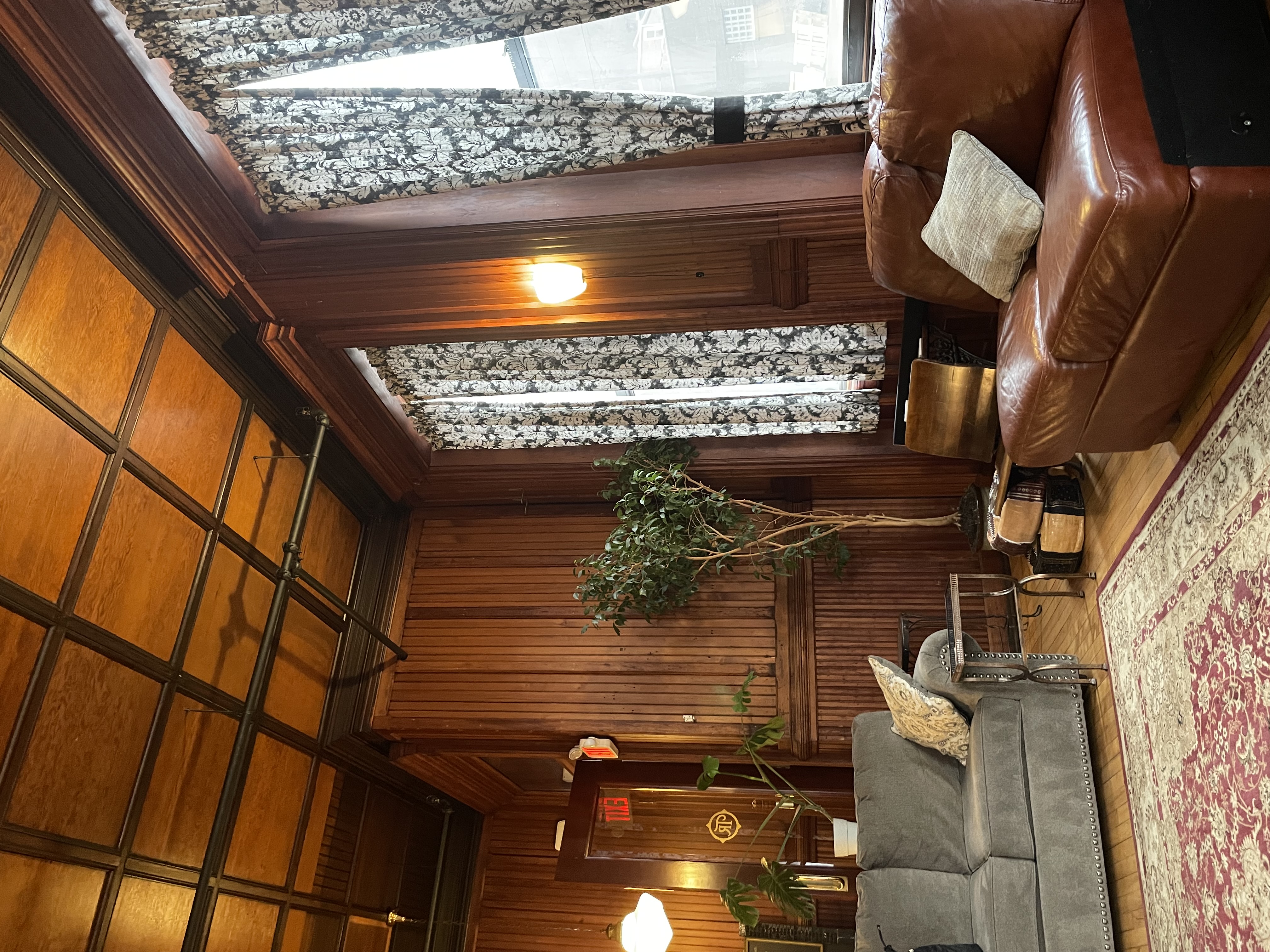 Leather sofas in a big room with old wood and ornate decor.