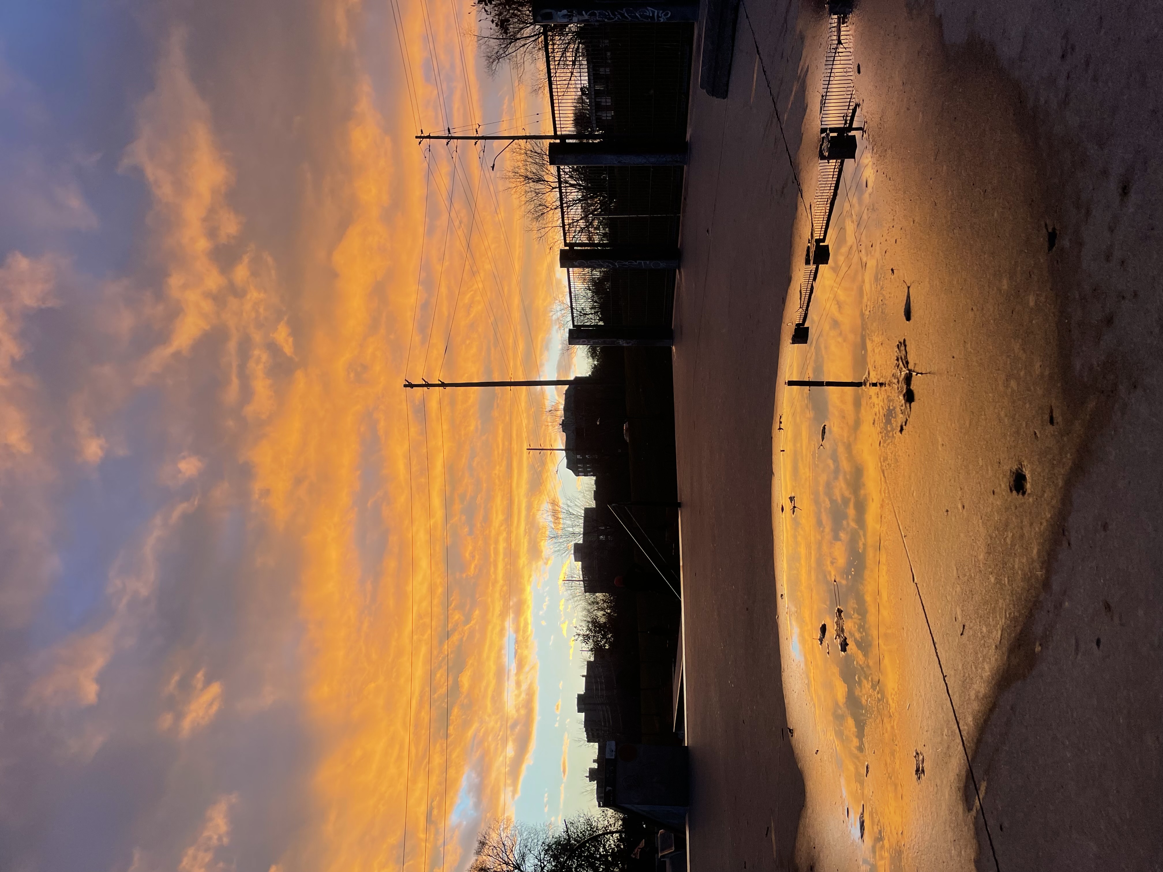 Beautiful orange sunset reflecting in a puddle at a skatepark.