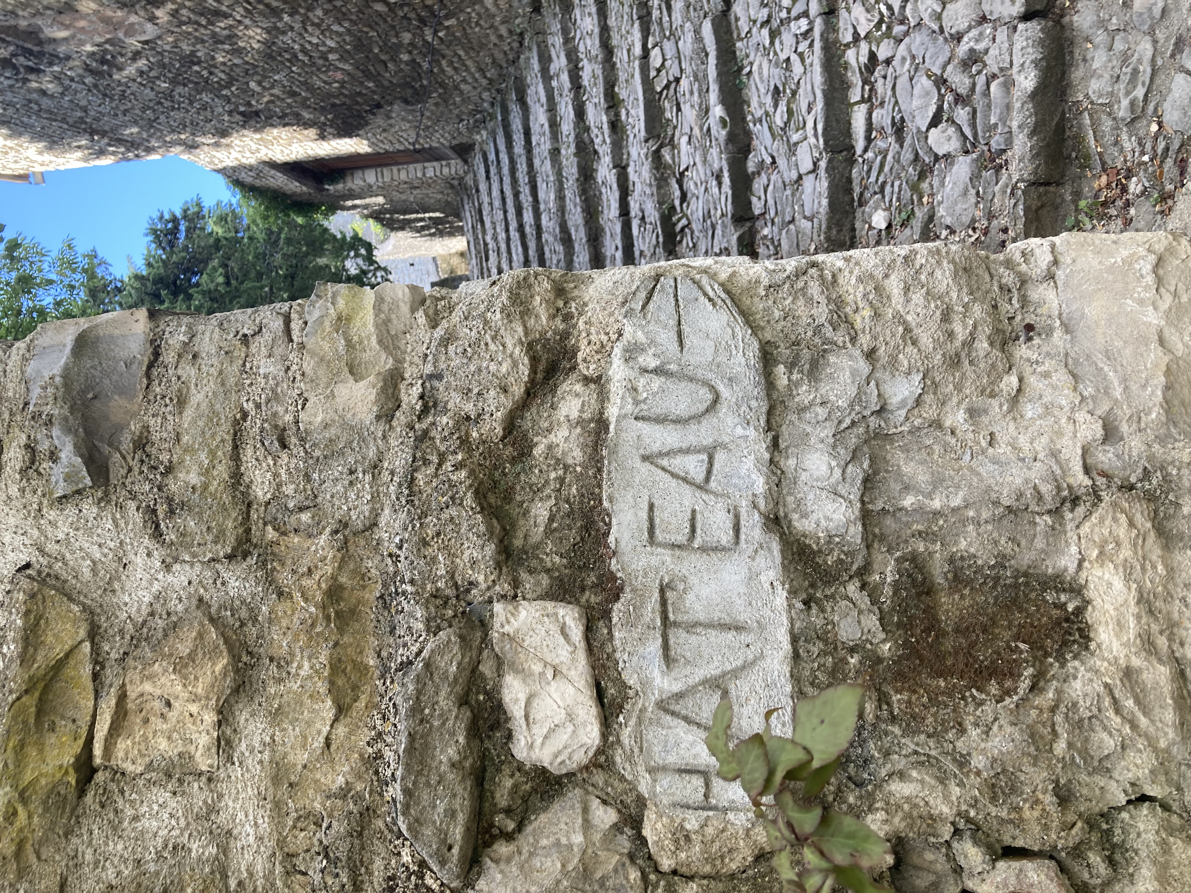 An old stone wall with 'Chateau' carved into the side.