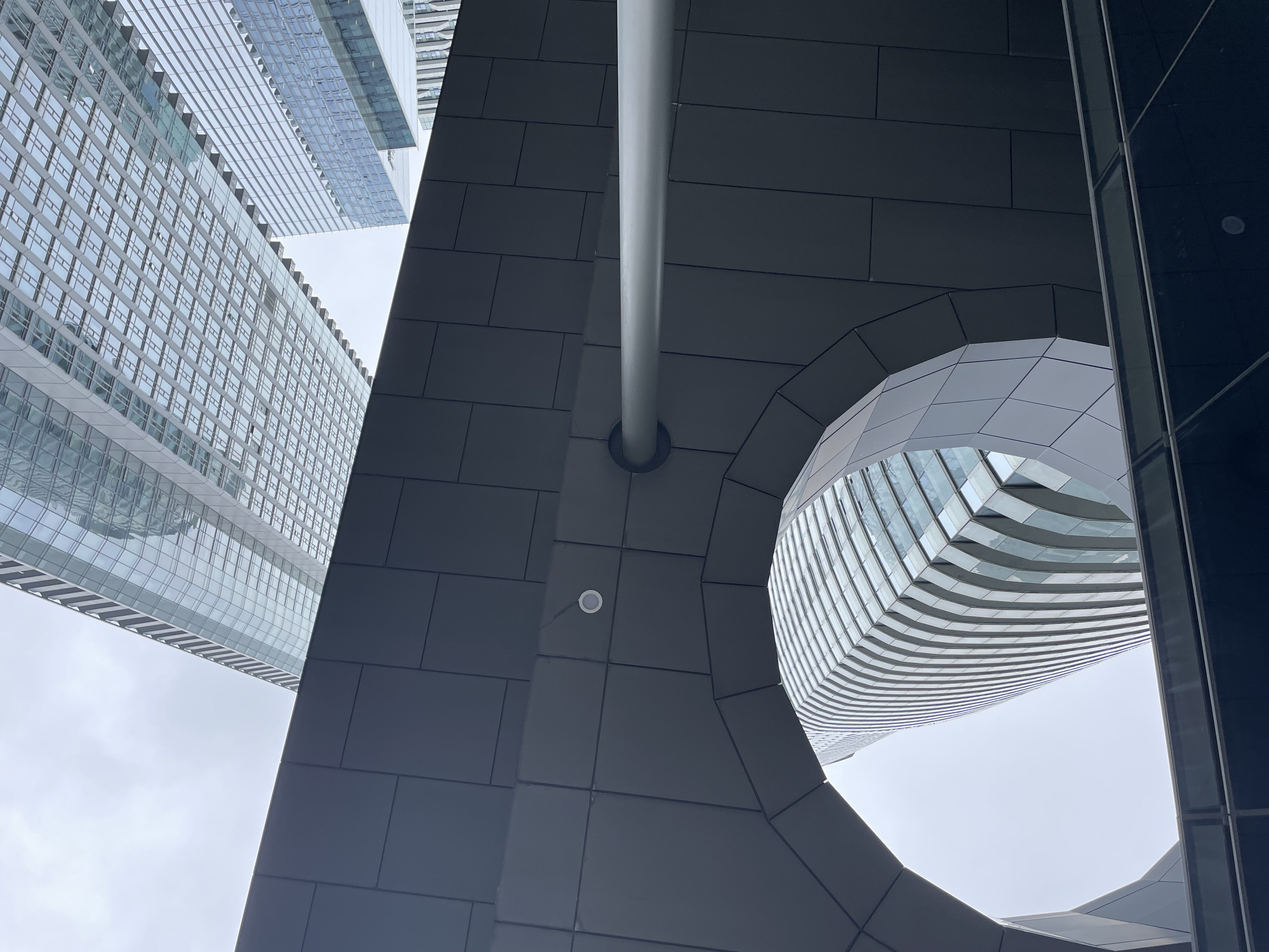 An image of an oddly shaped glass office building downtown Toronto.