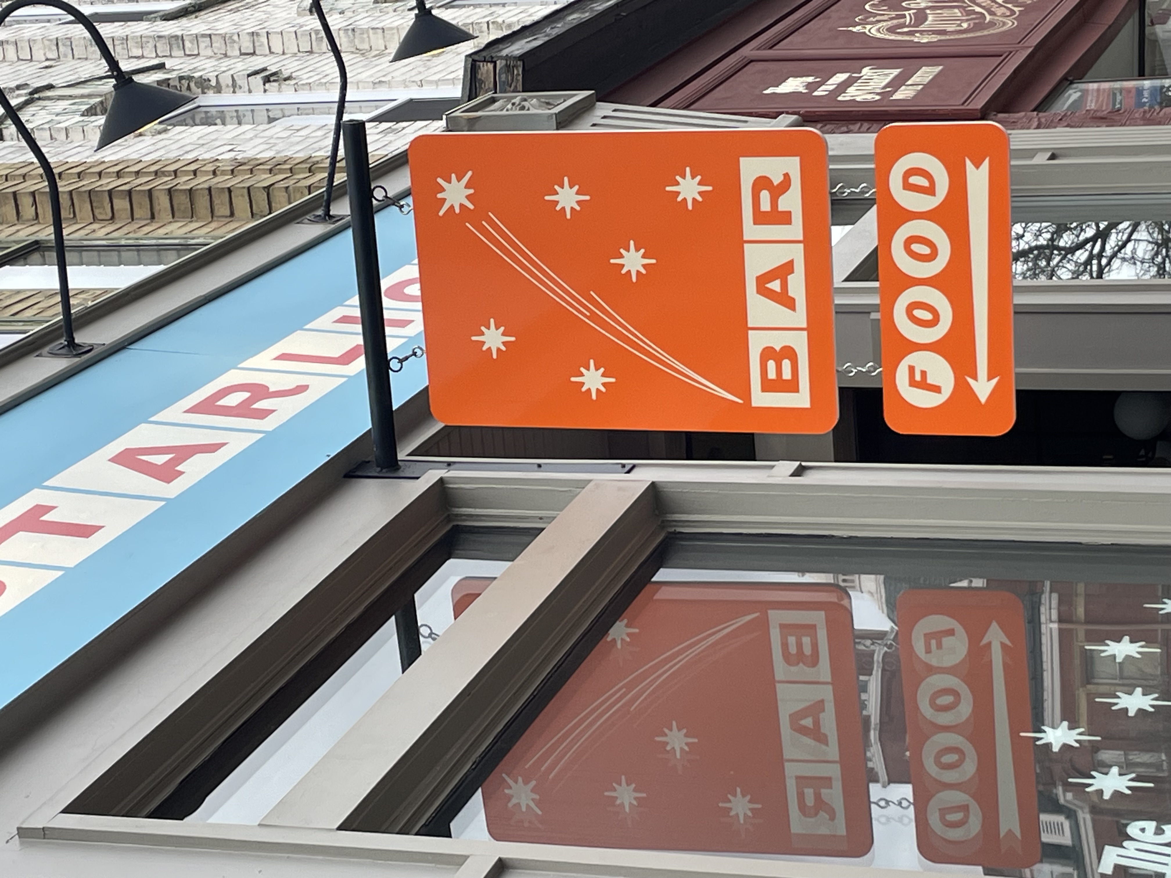 The storefront of the Starlight Cafe in Stratford, a blue front with a bright orange sign.