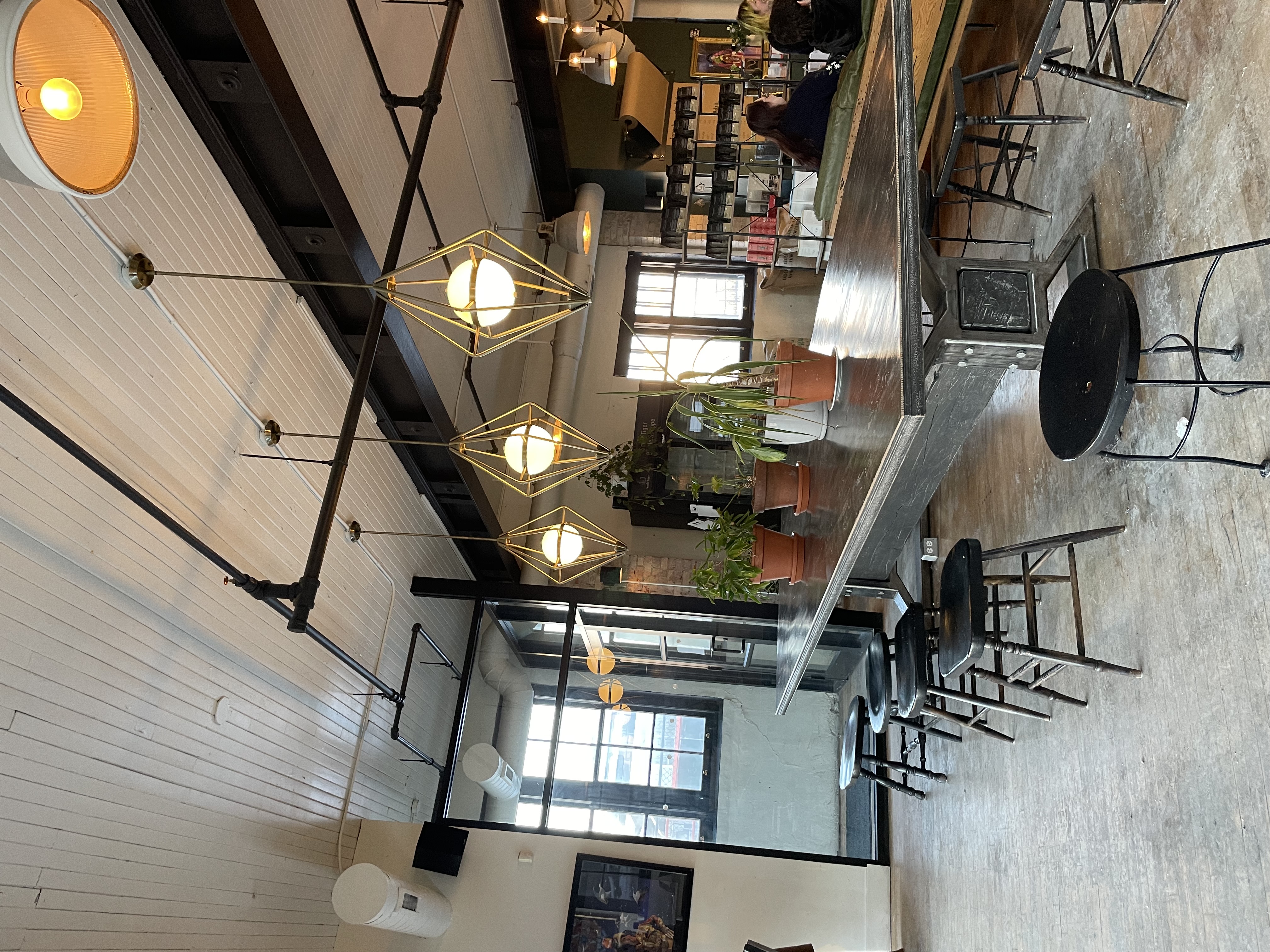 Image of a small cafe in Waterloo with cool gold lights and black stools.