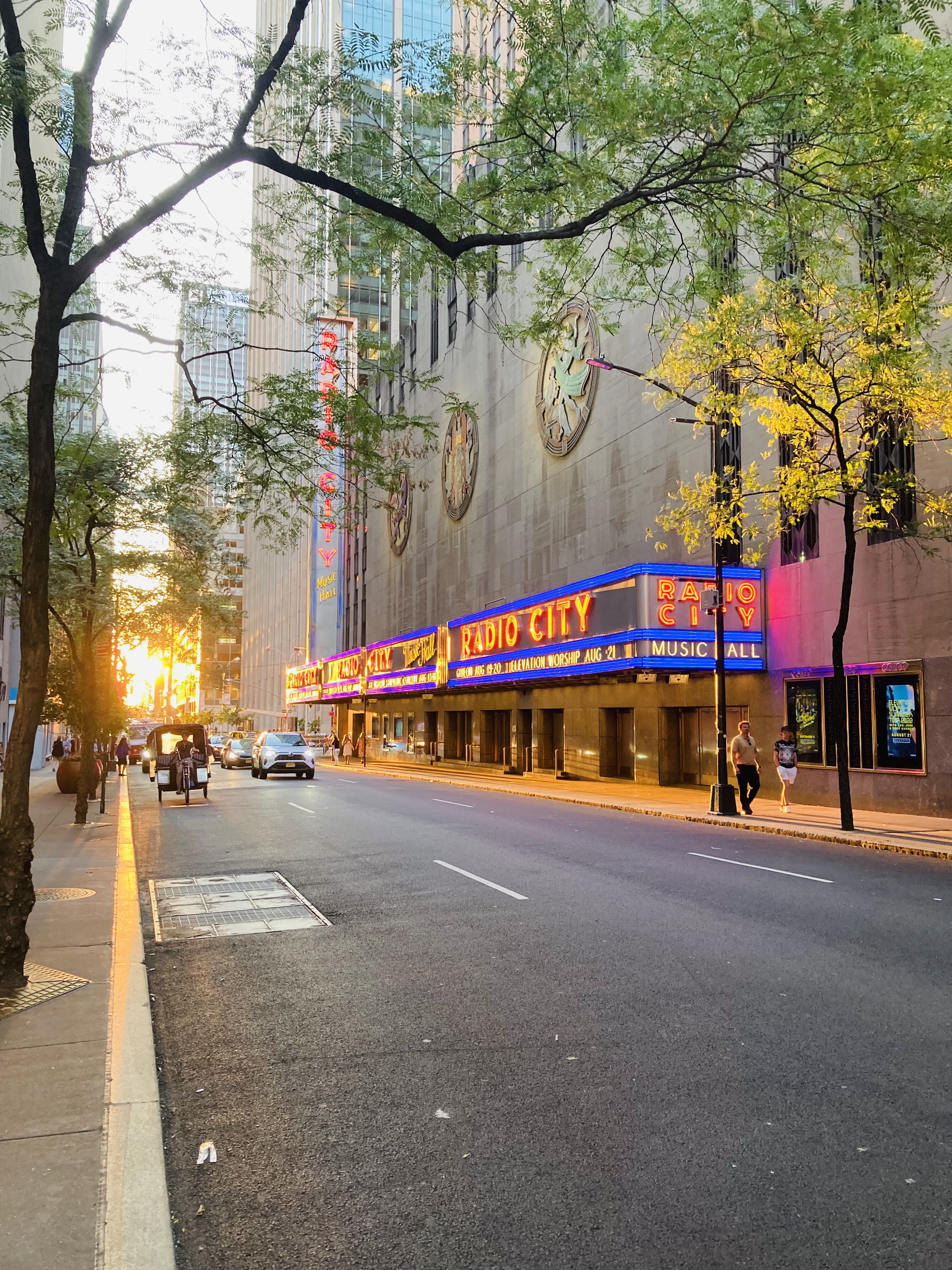 The sun setting behind the Radio City building in New York City.