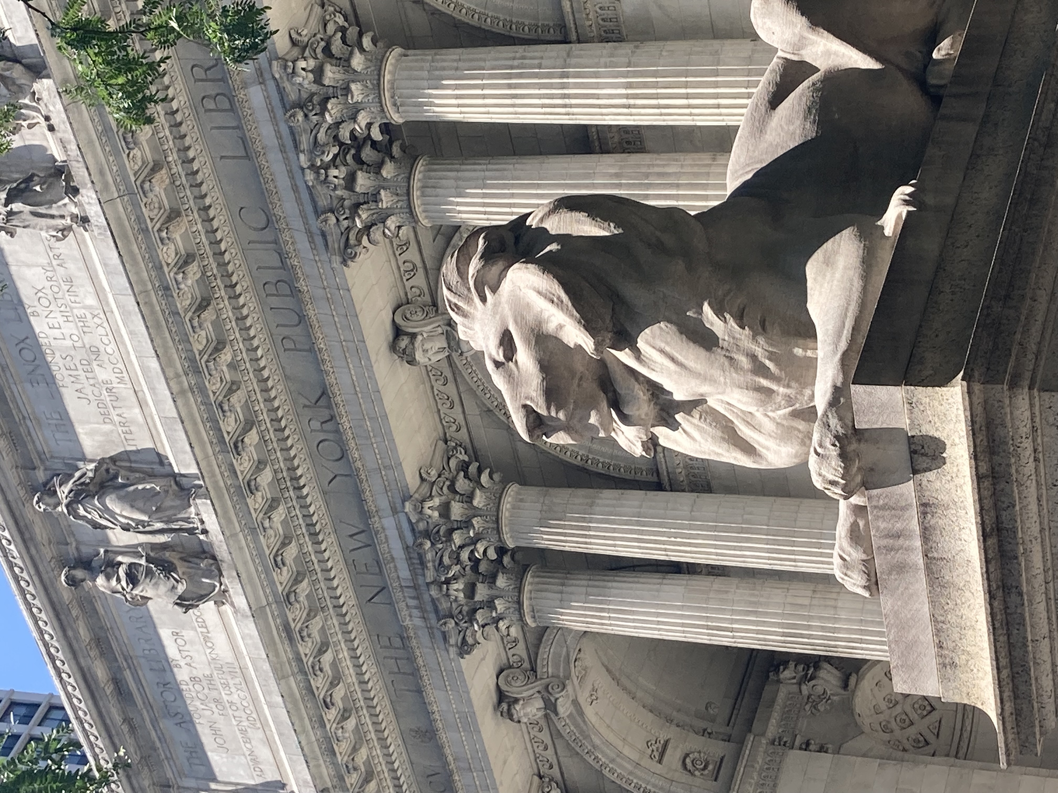 statue of a lion in front of the New York City public library.